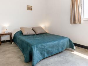 a bedroom with a bed with a blue blanket on it at Apartment Soleil Levant 1 et 2-2 by Interhome in Le Barcarès