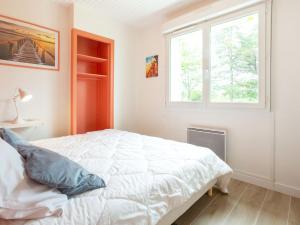 Un dormitorio con una cama blanca y una ventana. en Holiday Home Les mielles by Interhome, en Denneville-Plage