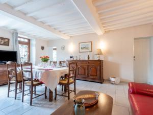 a dining room with a table and a couch at Holiday Home Le Repos by Interhome in Commes