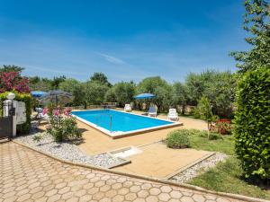 einen Pool im Garten mit Stühlen und Sonnenschirmen in der Unterkunft Holiday Home Sandra by Interhome in Rajki + 33 Fotos