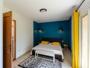 een slaapkamer met een bed en een blauwe muur bij Holiday Home Maison Christian by Interhome in Cervione