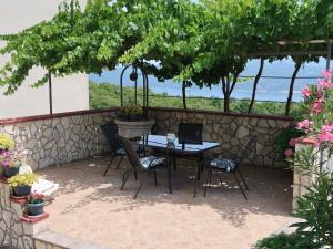 patio ze stołem i krzesłami pod drzewem w obiekcie Apartment Fonović - MOD115 by Interhome w mieście Plomin