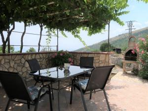 einen Tisch und Stühle auf einer Terrasse mit Kamin in der Unterkunft Apartment Fonović - MOD115 by Interhome in Plomin