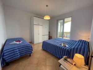 GiusteniceにあるApartment Bianca - PTL200 by Interhomeのベッドルーム1室(青いストライプのシーツを使用したベッド2台付)