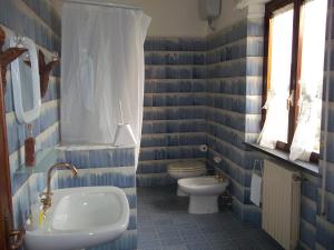 baño azul y blanco con aseo y lavamanos en Appartamento da Benito & Renza, en Lucca