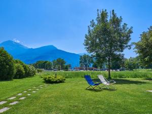 twee stoelen in het gras met bergen op de achtergrond bij Holiday Home Gelsomino by Interhome in Consiglio di Rumo