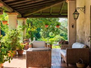 un patio al aire libre con sillas de mimbre y toldo con plantas en Holiday Home Le Querce by Interhome, en Fabrica di Roma