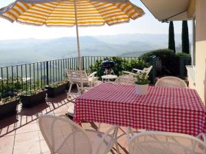 バローロにあるHoliday Home Baroncelli by Interhomeのテーブルと椅子、バルコニー(パラソル付)
