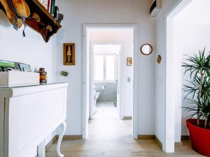 a hallway with white walls and a white console table and plants at Holiday Home Villetta ai Pini-2 by Interhome in Calceranica al Lago