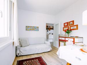 a white living room with a couch and a table at Holiday Home Villetta ai Pini-2 by Interhome in Calceranica al Lago