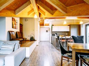 a living room and kitchen with wooden ceilings and a table at Apartment Deval-3 by Interhome in Calceranica al Lago +27 photos