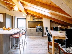 a kitchen with wooden ceilings and a table and chairs at Apartment Deval-3 by Interhome in Calceranica al Lago