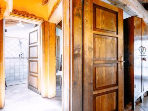 a bathroom with a wooden door in a room at Apartment Golden by Interhome in Sanzeno