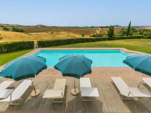 a group of chairs and umbrellas next to a swimming pool at Villa Casa dell'Arco by Interhome in Montemerano