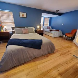 a bedroom with two beds and a blue wall at Garden 2 Storey House in Niagara Falls