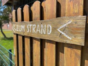a sign on a wooden fence with the word kiry stand on it at Apartment Nordseestern by Interhome in Norddeich