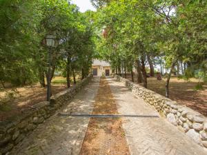a path in a park with trees and a building at Holiday Home Il Noceto by Interhome in Penne