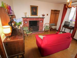 TraregoにあるHoliday Home Nicol by Interhomeのリビングルーム(赤いソファ、暖炉付)