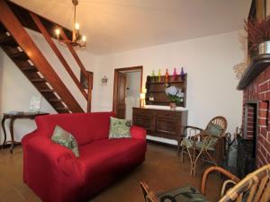 TraregoにあるHoliday Home Nicol by Interhomeのリビングルーム(赤いソファ、テーブル付)