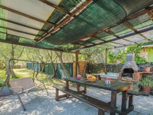 a patio with a picnic table and a stove at Holiday Home Italia by Interhome in Vorno
