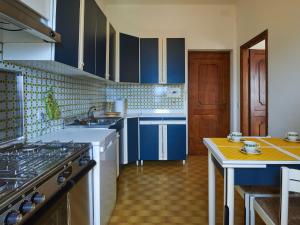 ドンゴにあるApartment Home Sweet Home by Interhomeの青いキャビネットとテーブル付きのキッチンが備わります。 +15枚の写真