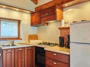 una cucina con armadi in legno e frigorifero bianco di Holiday Home Antonia by Interhome a Livo