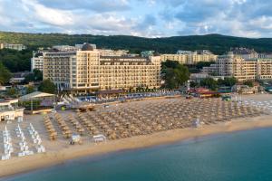 una playa con sillas y sombrillas y un hotel en Admiral Hotel - Ultra All Inclusive & Private Beach, en Golden Sands