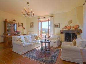 a living room with white couches and a fireplace at Apartment Casetta by Interhome in Poggibonsi