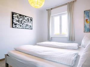 two beds in a white room with a window at Holiday Home Villetta ai Pini-1 by Interhome in Calceranica al Lago