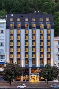 a large building with lights on in a city at Hôtel Miramont in Lourdes