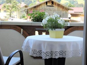 een tafel met een wit tafelkleed en bloemen op een balkon bij Apartment Monika-1 by Interhome in Gattererberg