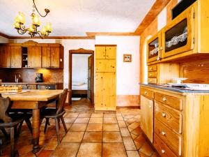 a kitchen with a wooden table and a dining room at Apartment Canada by Interhome in Sanzeno