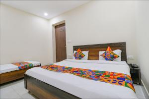sypialnia z 2 łóżkami w pokoju w obiekcie FabExpress Kartikey Inn w mieście Haridwar