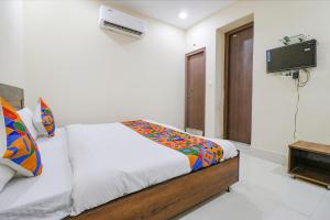 1 dormitorio con 1 cama y TV. en FabExpress Kartikey Inn, en Haridwar