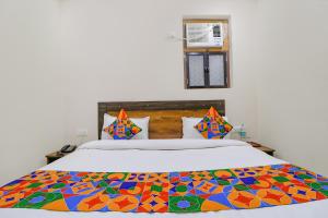 sypialnia z łóżkiem z kolorowym kocem w obiekcie FabExpress Kartikey Inn w mieście Haridwar