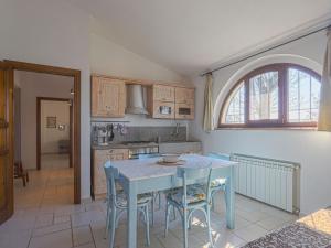 una cucina con tavolo, sedie e finestra di Holiday Home Podere San Raffaele - Cinzia by Interhome a Poggibonsi