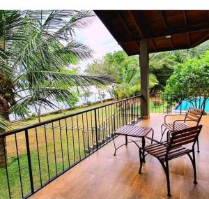 two benches sitting on a porch with a fence at Kaaya Eco Resort Yala in Tissamaharama