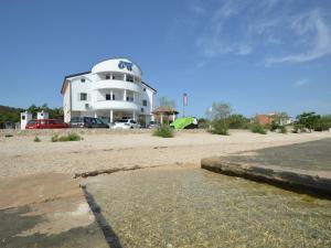a building on the beach with a body of water at Apartment Ivana-2 by Interhome in Raslina