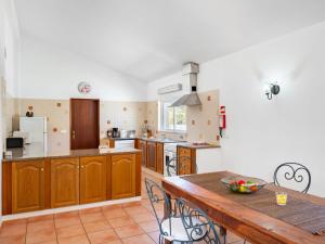 een keuken met houten kasten en een houten tafel bij Holiday Home Monte Quercus by Interhome in Porches +15 foto's