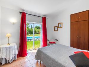 a bedroom with a bed and a sliding glass door at Holiday Home Monte Quercus - PRH100 by Interhome in Porches