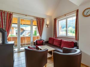 Una sala de estar con un sofá y sillas y ventanas. en Apartment Top 6 by Interhome, en Sankt Margarethen im Lungau