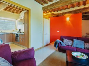 a living room with two purple couches and an orange wall at Apartment Rustico dei Canali by Interhome in Castelvecchio +28 photos