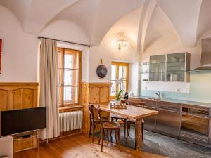 a kitchen with a wooden table and a dining room at Apartment Chesa Chascharia 1 by Interhome in Samedan