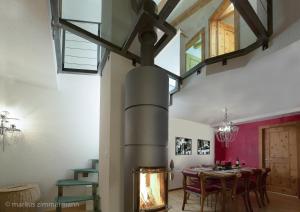 comedor con chimenea y mesa en Haus Maryland, en Zermatt