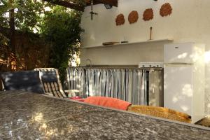 a kitchen with a counter with a refrigerator and chairs at Villini Sulla Spiaggia in Capoliveri