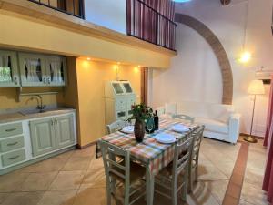 Una cocina y una sala de estar con mesa y sillas. en Apartment Istrice-10 by Interhome, en Riparbella 34 fotos más
