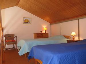 レ・サ​​ーブル・ドロンヌにあるHoliday Home Le Goeland Argenté by Interhomeのベッドルーム1室(青いシーツと椅子付きのベッド2台付)