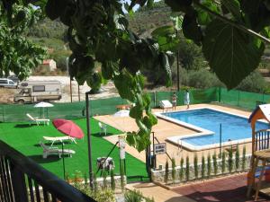 uma piscina com mesa de piquenique e guarda-sol em L'Almàssera Casa Rural & Restaurant em Margarida