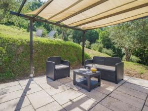 eine Terrasse mit 2 Stühlen und einem Tisch unter einem Baldachin in der Unterkunft Holiday Home Buratto by Interhome in Monsagrati
