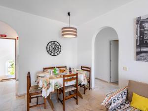 een eetkamer met een tafel, stoelen en een klok bij Apartment Quinta do Torrejão by Interhome in Porches